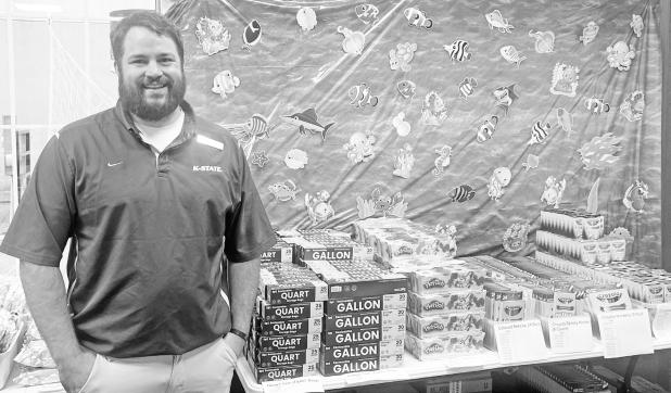 Pharmacist Jake Dugan stands with a portion of the many school supplies that The Apothecary has purchased for its annual school supply giveaway. Beginning today, Monday, July 27, Council Grove Elementary School students in pre-kindergarten through sixth grade and Prairie Heights Elementary School students in kindergarten through sixth grade may receive a backpack and grade-appropriate supplies at no cost. The Council Grove giveaway represents an investment of more than $20,000 in area students and families.