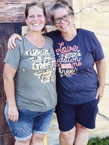 Sisters Tracy Waring and Janene Parcel pose by the themed mural they painted at the Community Thrift Store. The art was a work of love in memory of their mother Joan Rothwell who died July 14. A section of the mural above is dedicated to Rothwell.