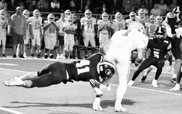Council Grove Braves senior Bradley Doornbos (No. 41) dives to tackle a Riley County Falcon during Friday night’s football game at Legion Stadium. The Braves lost 22-21. Photo: Amber Weeks