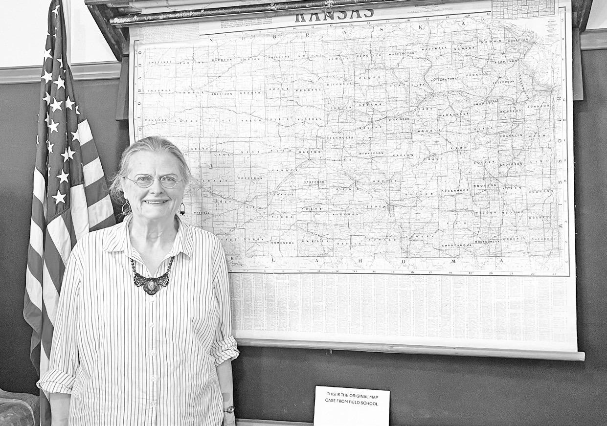Shirley McClintock, curator of Trail Days Historic Site, poses by the Kansas map which is part of the Field School’s pull-down maps collection. Field School is open to visit during Trail Days Cafe hours and by appointment. The attention to detail in the