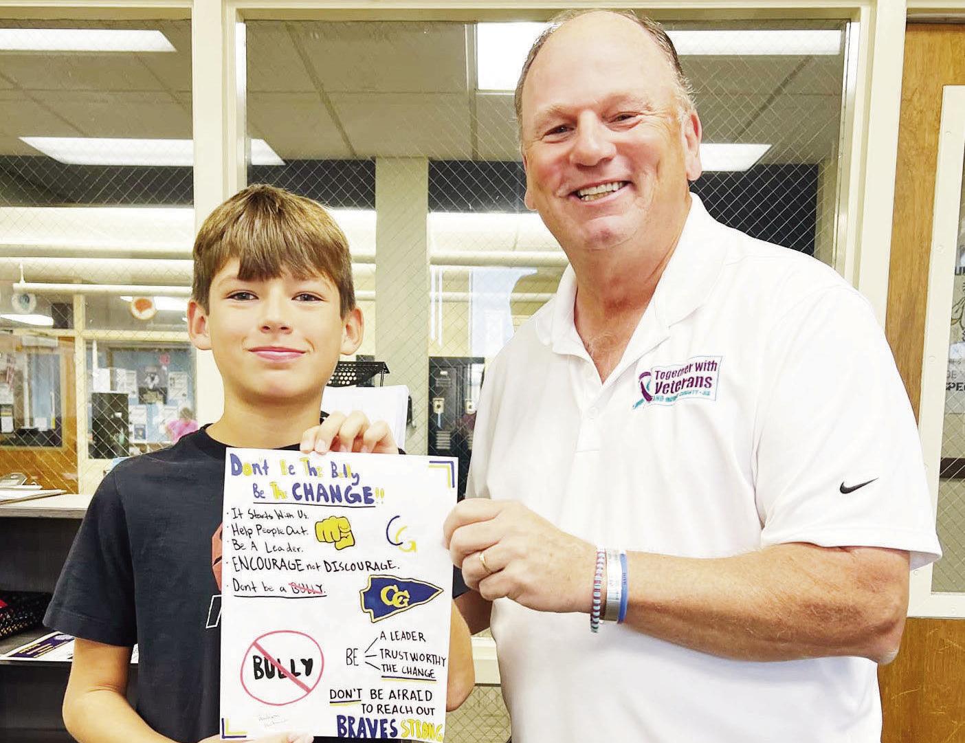 Hudson Hartman (left) was selected as the USD 417 “Be The Change” poster winner. Hudson received a check for $100 by Jim Crosby with Together with Veterans AND Morris County. “Be The Change” is an anti-bullying campaign that empowers students to r