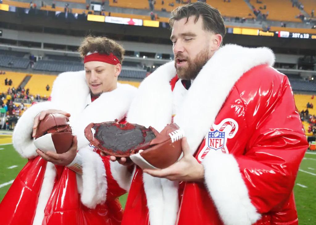 NETFLIX MVP WINNERS -- Kansas City Chiefs quarterback Patrick Mahomes (left) and tight end Travis Kelce (right) open their Netflix Christmas GameDay cake after the Chiefs defeated the Pittsburgh Steelers at Acrisure Stadium. The robes were part of their M