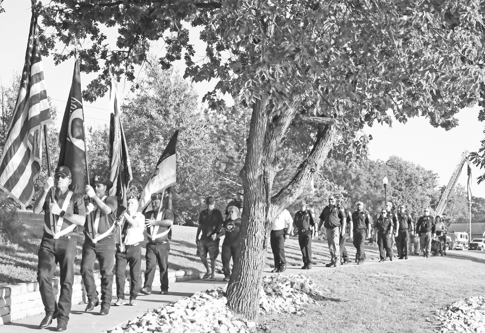 A color guard led Thursday’s Patriot Day Walk in Herington. Walkers included local first responders and community members. Stops were made during the walk around Father Padilla Pond to honor all those lives lost in the 9/11 attack on Americans. Photo: S