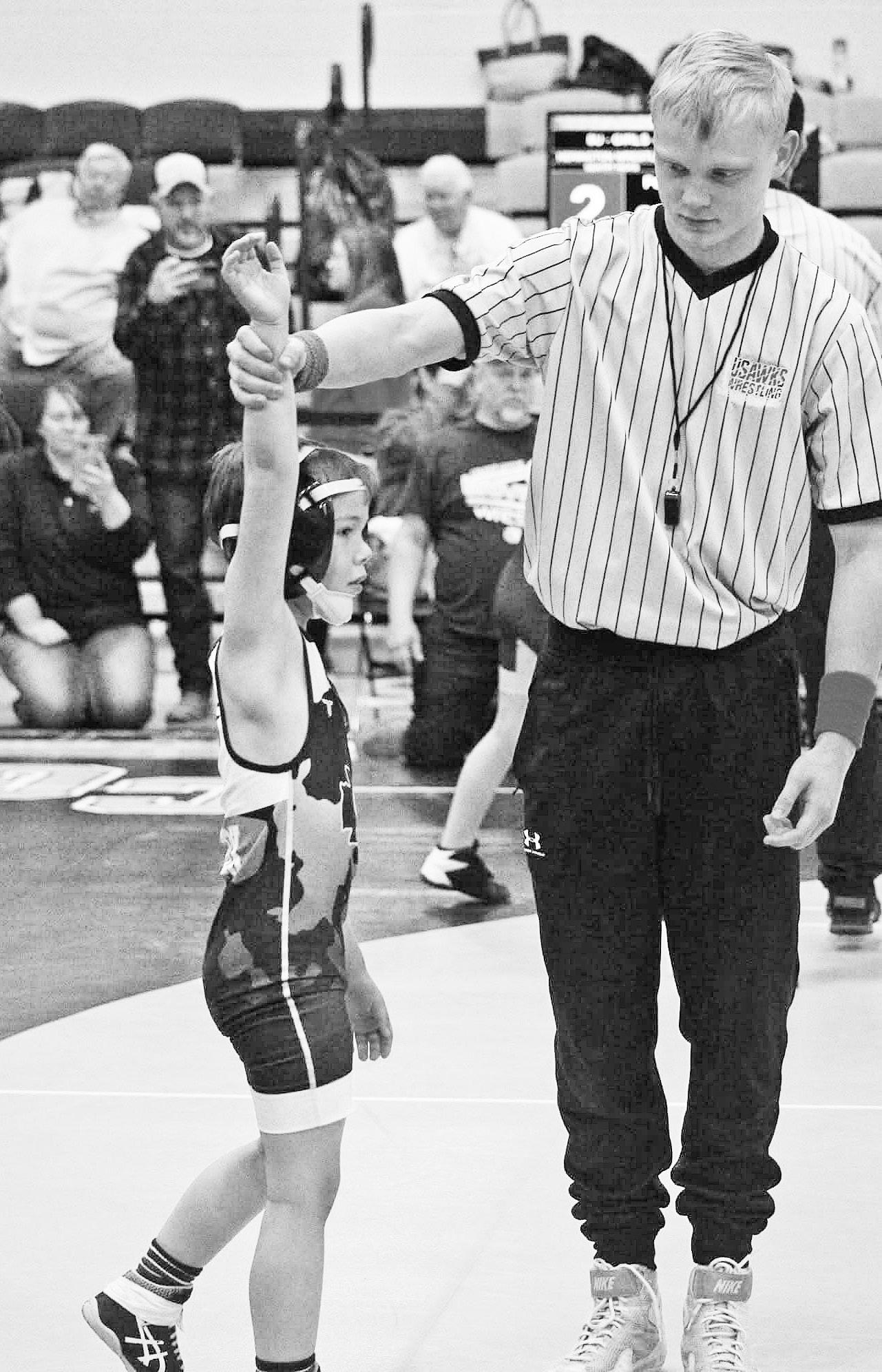 WINNING AND SERVING . . . Bradley Dornbos won the wrestling tournament title during the weekend and served as an official on Sunday where he got to officiate Knute Fox winning a couple of matches.