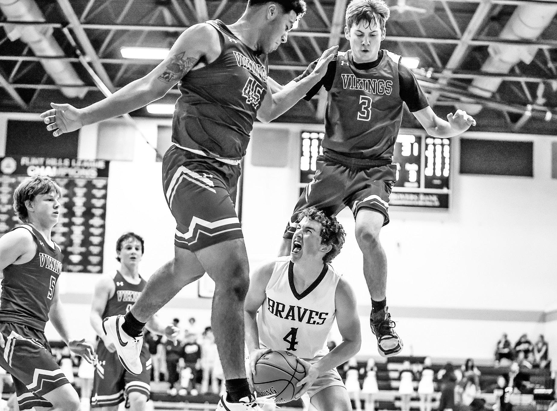 FIGHTING THE VIKINGS -- Council Grove Brave and Senior Drew Buchman found himself surrounded by Mission Valley Vikings when the Braves hosted Mission Valley. The Braves came away with a 49-36 victory. (Photo by Brandy Villalobos)