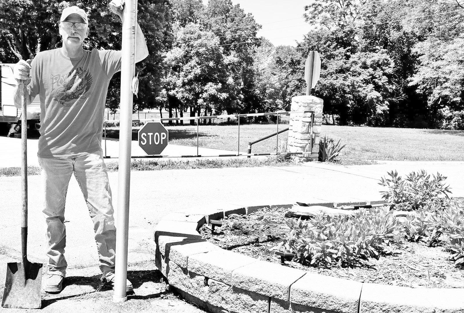 COMMUNITY SPIRIT . . .Thad Schneider, of Council Grove, repairs damage to the flower bed at the entrance to Richey Cove at Council Grove Lake, after an unknown vehicle struck the structure and left the scene. With the lake operating under a federal hiring