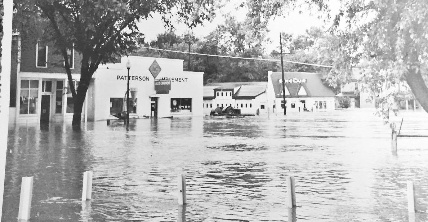 New life for an old building . . . The new CrossWinds location is pictured in the old 1950 flood photo as an Allis Chalmer dealership owned by Harrison Pat Patterson and later by his son Laurence Maddux. The building is now remodeled into CrossWinds Couns