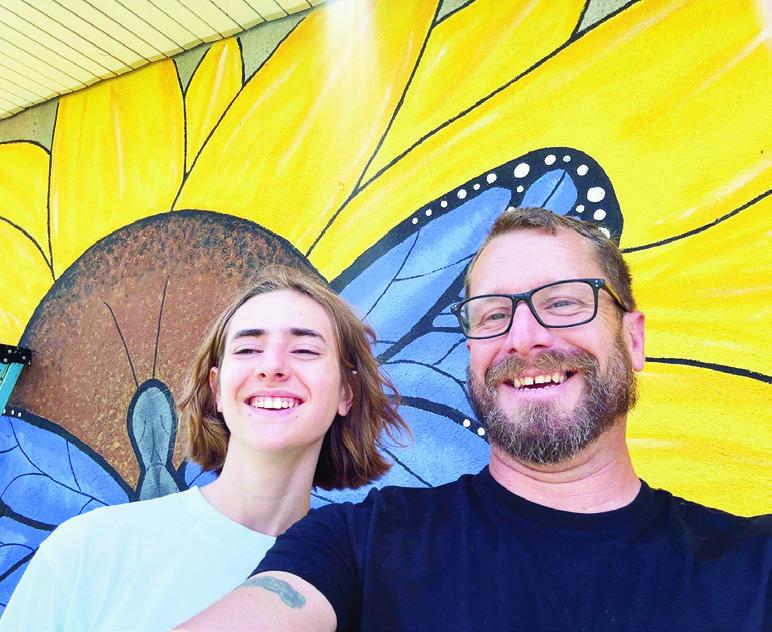 The mural called “A. M. Garden” was created by local high schooler Anna Bachura (pictured right with Bob Alexander) and completed with assistance from building owner Misti Haas and volunteers Sue and Jim Crosby, Ashley Spaulding, Christy Alexander, Mi