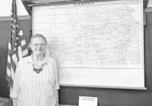 Shirley McClintock, curator of Trail Days Historic Site, poses by the Kansas map which is part of the Field School’s pull-down maps collection. Field School is open to visit during Trail Days Cafe hours and by appointment. The attention to detail in the
