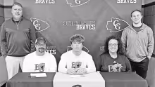 PLAYING FOR BAKER . . . Last week Ace Monihen signed his National Letter of Intent to play football at Baker University. He is seated with his parents Aaron and Cheryl Monihen. Butch Hayes (left) and Derron Reddick (right) were present for the honors.