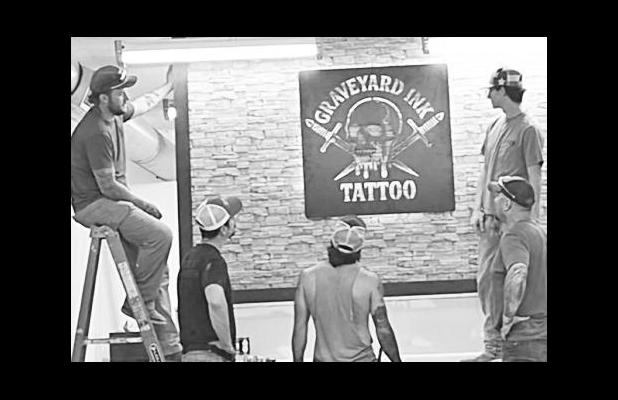 It was a group effort installing a Graveyard Ink sign in the new studio. From left to right are Cooper Blackledge, Scott Baughman, Corbyn Miller, Tisen Flatery (next to sign) and Chris Blackledge.