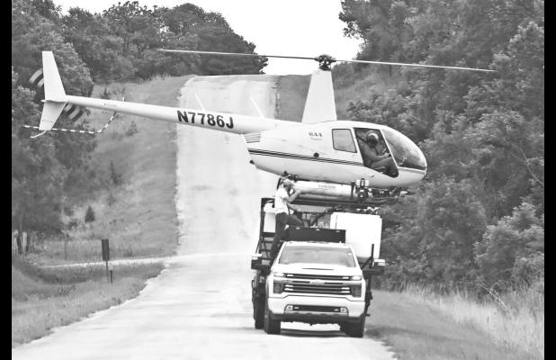 A crop-dusting helicopter was captured having its chemical tank refilled from a truck on Lake Road on June 6. The stunning photo was captured by Chase County resident Theresia Martin.
