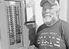 Tom Van Valkenburg, Director of Facilities at USD 417, stands beside an electrical panel in the 1960s addition of the school where every breaker slot is full, with no room for expansion.