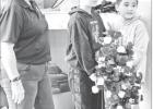 PATRIOT DAY -- Rebecca Elias assists while Elmer Yoder (middle) and Thomas Campbell (right) handle a wreath honoring patriots and first responders at the Patriot Day celebration in Council Grove Monday. PATRIOT DAY