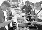 PACKAGING chicken fried rice for distribution in the Kids Feeding Kids project. Pictured left to right are - Mason Wilkens, Maya Mulryan, Mia McCormick (in background), Mr. Meals, Milo Nelson and Morgan Romme.